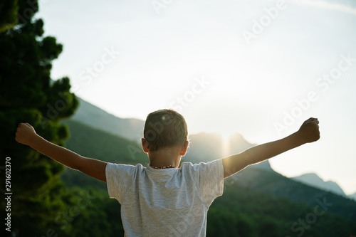 Фотография Young boy standing outside at sunrise