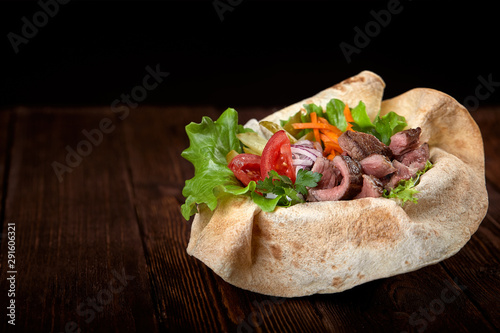 Turkish and Arabic Traditional Ramadan mix kebab plate. Kebab beef on lavash bread with sauce and vegetables.