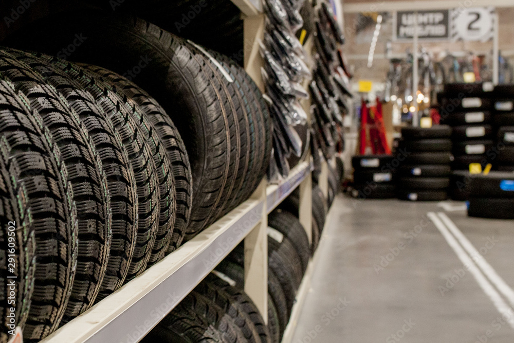 Fototapeta premium Car tires and wheels at warehouse in tire store.