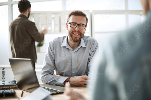 close up. smiling businessman sitting at his Desk photo