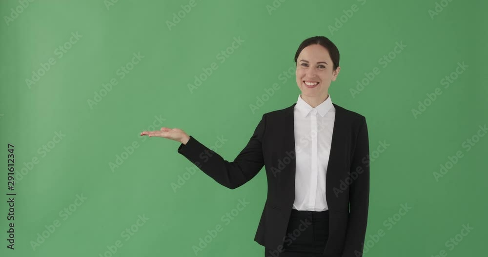 Businesswoman presenting copy space on her palm of hand over green background Businesswoman presenting copy space on her palm of hand over green background