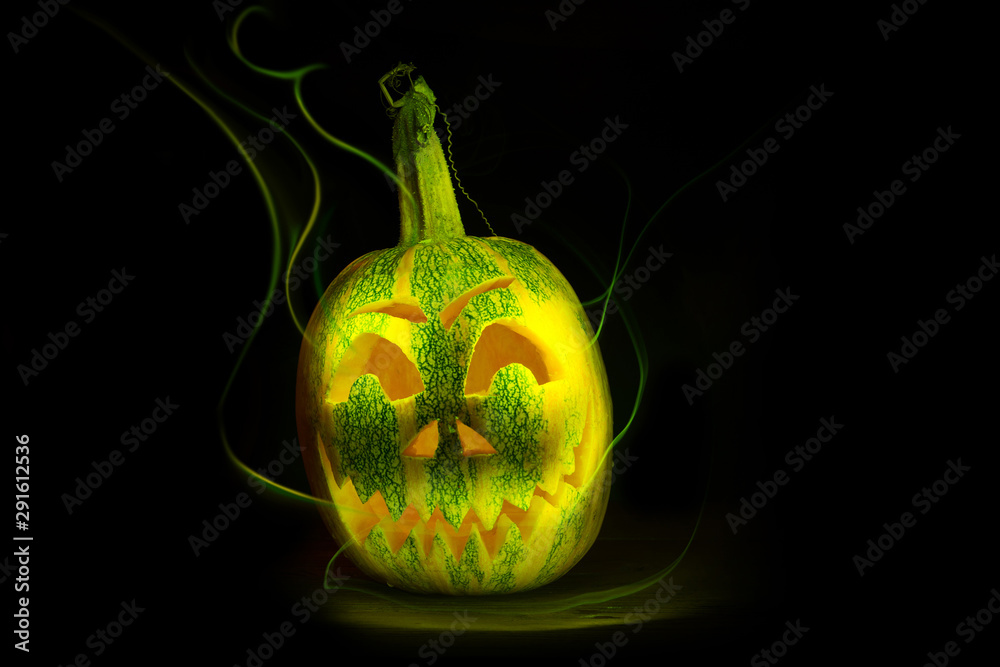 Obraz premium luminous pumpkins in the dark for the autumn Halloween holiday. Jack's grinning head. Magical bright neon green and yellow light in the darkness of Freezelight. All Saints' Day