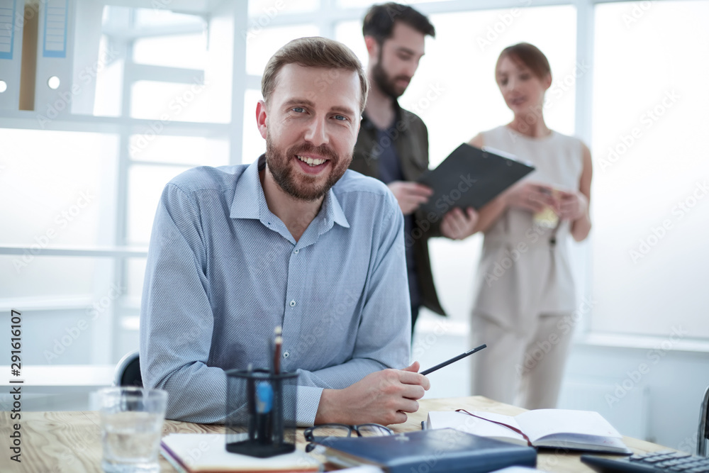close up.smiling business man sitting at a Desk close up.smiling business man sitting at a Desk