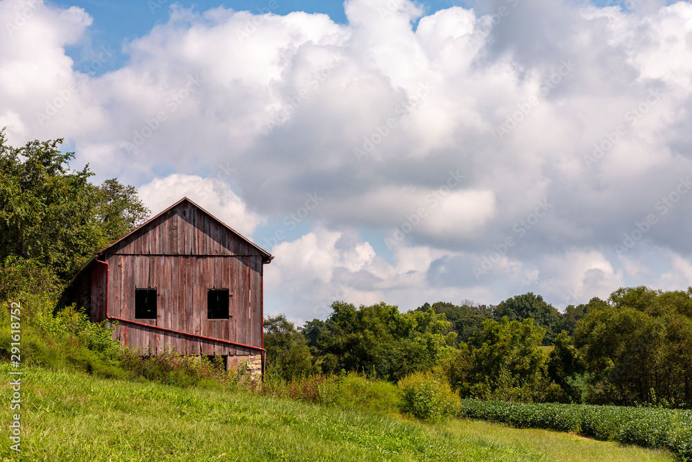 landscape of a red barn on a hillside on a cloudy summer day landscape of a red barn on a hillside on a cloudy summer day