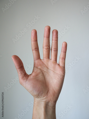 man put hand up his hand on white wall background.