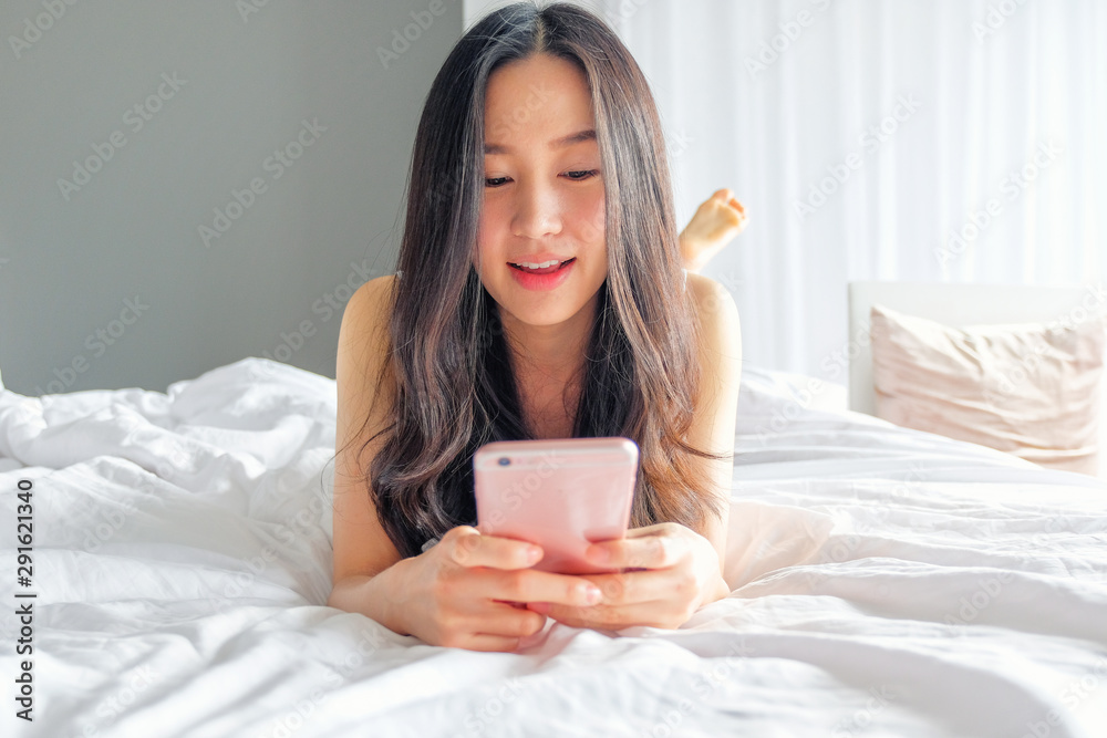 Yound woman using smart phone on the bed Yound woman using smart phone on the bed