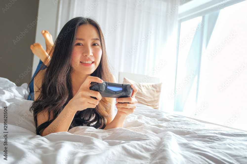 Beautiful girl playing video game on bed Beautiful girl playing video game on bed