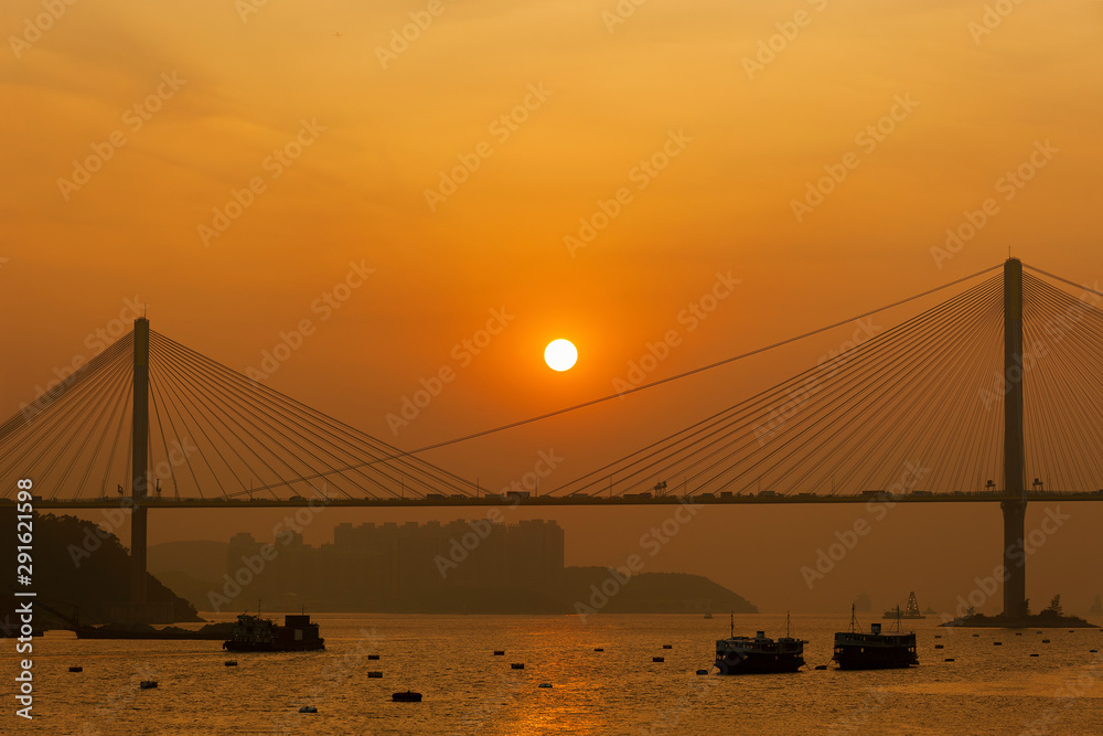 Obraz premium Sunset over suspension bridge in Hong Kong city