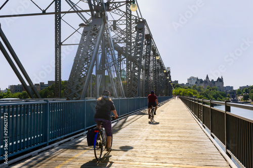bridge open to walking and cycling pedestrian friendly wooden vintage bridge in Ottawa and two cyclists photo