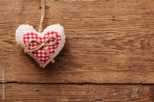 Handmade heart of scrim hanging on a wooden wall