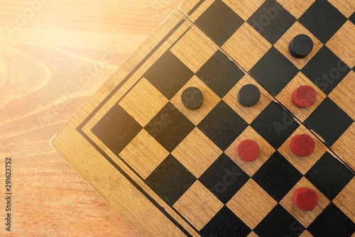 Checkers board on wood background with softlight