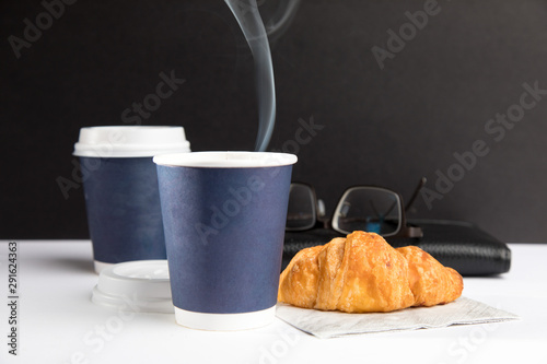 steam rising from a dark blue paper coffee cup