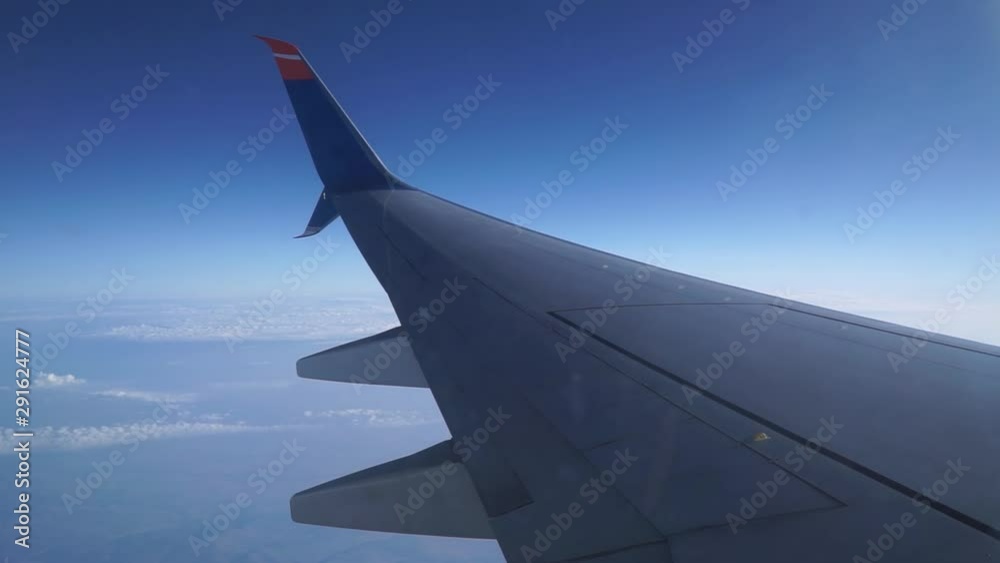 wing of airplane flying above clouds wing of airplane flying above clouds