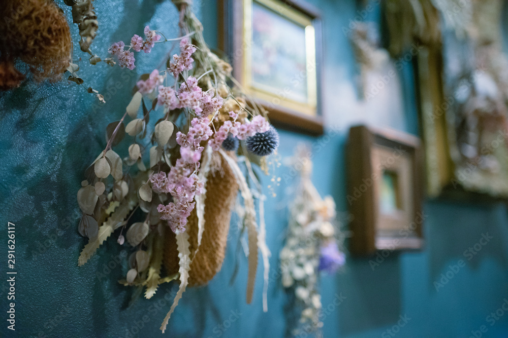 青い壁にかけられたドライフラワーのスワッグと額縁 Stock Foto Adobe Stock 青い壁にかけられたドライフラワーのスワッグと額縁 Stock Foto Adobe Stock