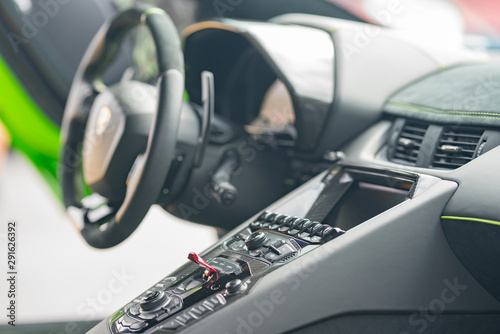 Interior photo of a Lamborghini sports car showing buttons and steering wheel photo