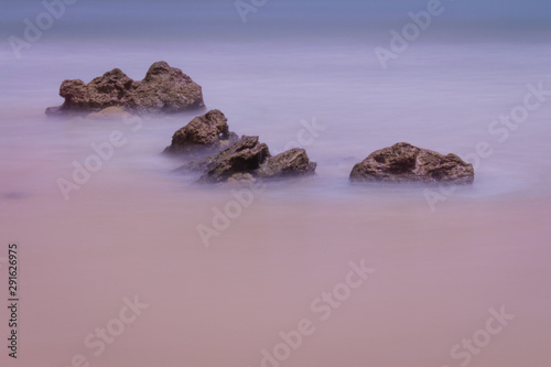 Smooth silk effect on sea rocks. Water strokes that produce a blurry effect on the rocks.