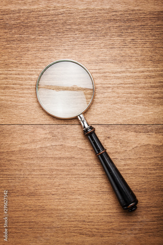 Magnifying glass on wooden background