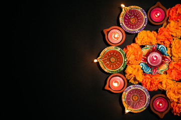 Happy Diwali - Clay Diya lamps lit during Dipavali, Hindu festival of lights celebration. Colorful traditional oil lamp diya on white background