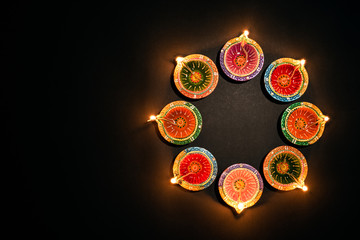 Happy Diwali - Clay Diya lamps lit during Dipavali, Hindu festival of lights celebration. Colorful traditional oil lamp diya on white background