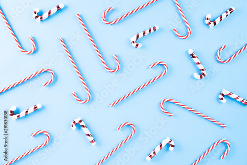 Christmas holidays composition Top view of Christmas tree decoration  candy cane and red berries on blue pastel background with copy space for text.