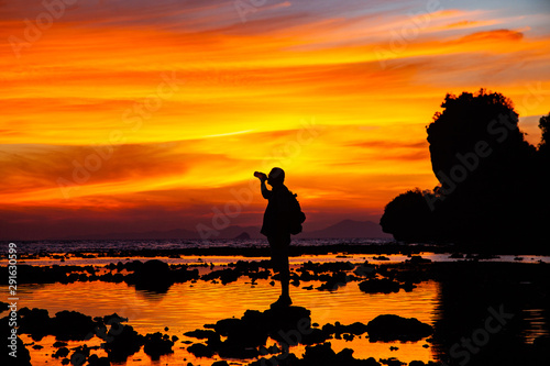 man silhouette watching amazing sunset on the beach in Krabi  Thailand
