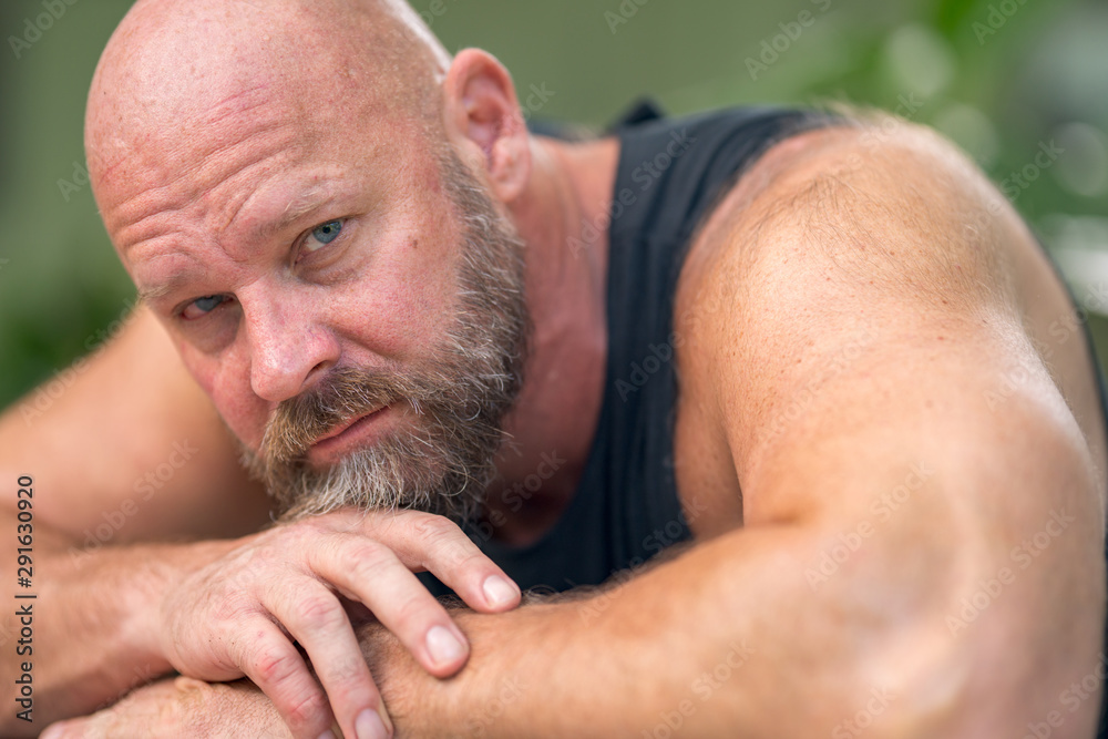 Obraz premium Photo of a man laying his head on arms looking into camera