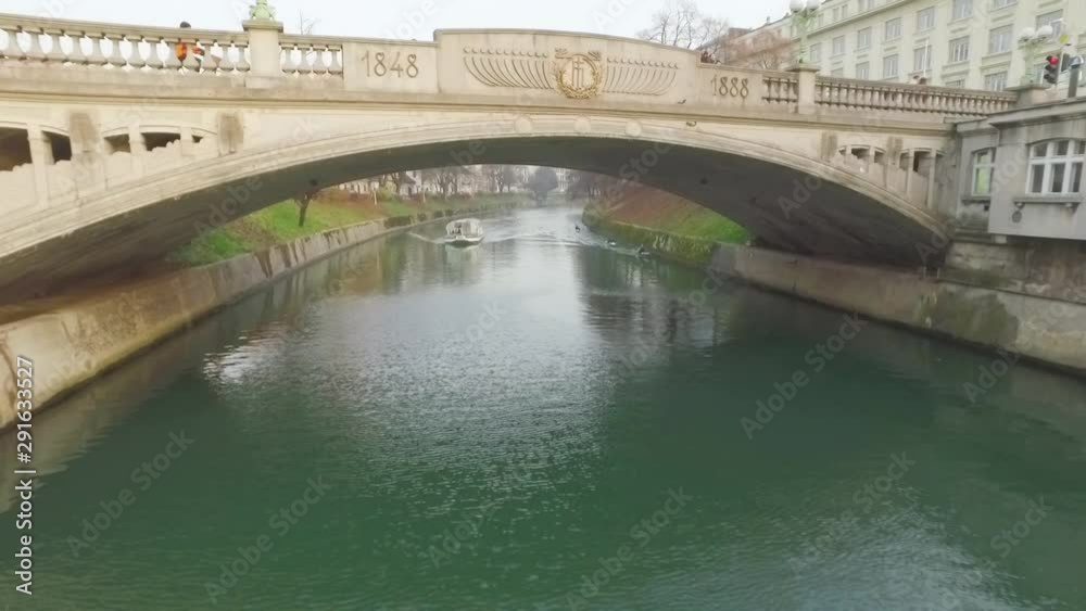 Little touristic boat cruise on its usual route over river Ljubljanica in Ljubljana, Slovenia. Little touristic boat cruise on its usual route over river Ljubljanica in Ljubljana, Slovenia.