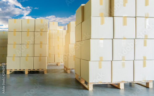 stack cardboard boxes on wooden pallets with a blue sky, cargo courier shipment, warehouse industry logistics and transportation