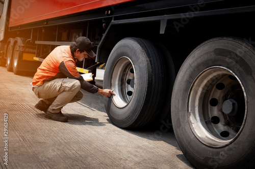 Asian Truck Driver is Checking the Truck's Safety Maintenance Checklist. Inspection Truck Safety of Semi Truck Wheels Tires. Auto Service Shop. 