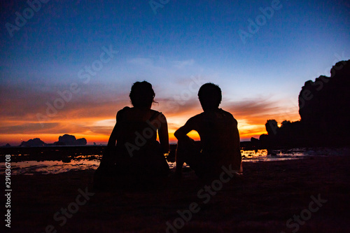 couple silhouette watching amazing sunset on the beach in Krabi Thailand