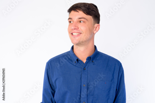 Face of happy young handsome businessman thinking and looking up