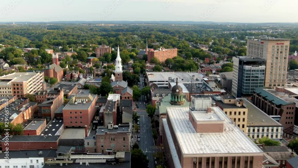 Aerial dolly shot of Lancaster City in Pennsylvania USA  revealing court house, church steeples, buildings on sunny summer evening