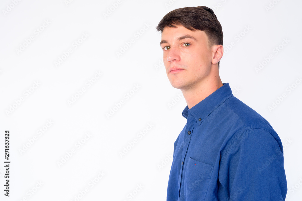 Closeup profile view of young handsome businessman looking at camera Closeup profile view of young handsome businessman looking at camera