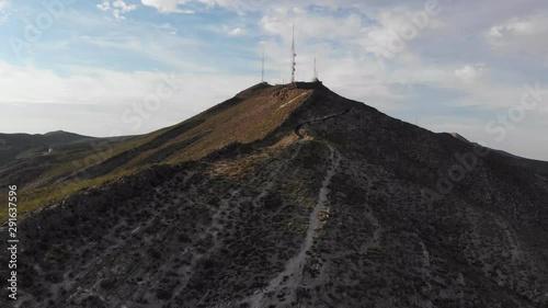 Aerial drone shot of the southern tip of the Franklin Mountain range, part of the Rockies. Also includes communication towers and the dirt road winding along the top of the mountain. photo