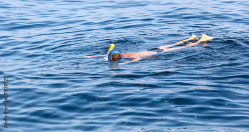 A man swims in the blue water of the sea © schankz