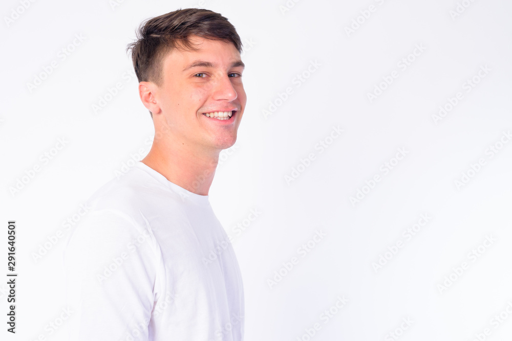 Closeup profile view of happy young handsome man looking at camera Closeup profile view of happy young handsome man looking at camera