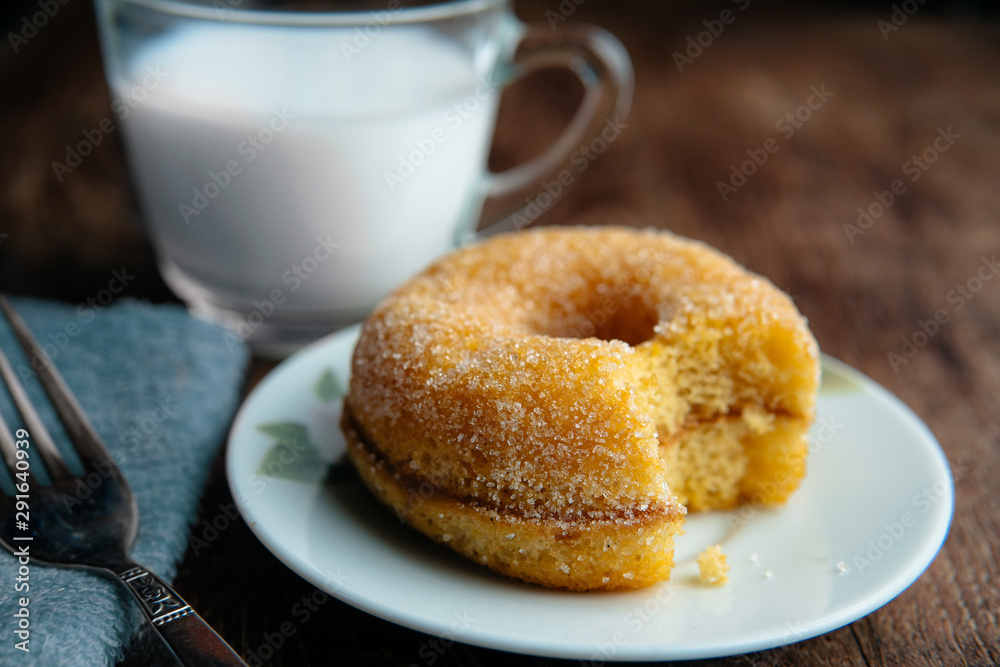 Tasty fluffy yeast doughnuts or sugared donut on white plate and glass of milk on wood table, Best Morning recipe. Tasty fluffy yeast doughnuts or sugared donut on white plate and glass of milk on wood table, Best Morning recipe.