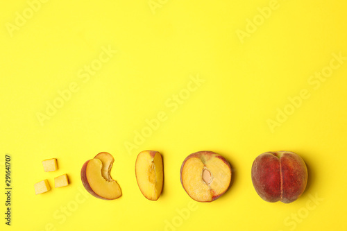 Flat lay composition with ripe peaches on yellow background, space for text