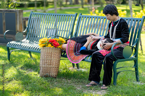 Pretty Young Girlfriend Lying on the Lap of her boyfriend While Relaxing at the Public Park, Mhong couple in valentine day. photo