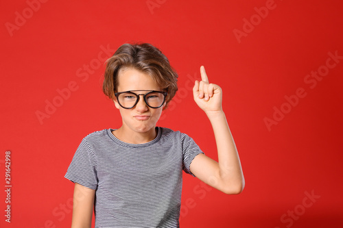 Cute little boy in casual outfit on red background