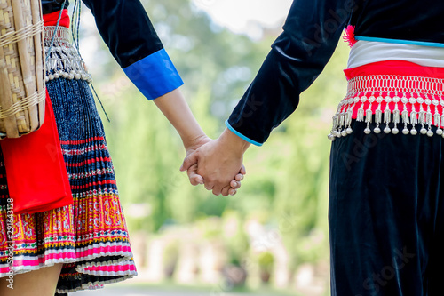 Happy young couple walking hand in hand and promised to take care of each other with love and caring. Lovers, Friendship and Valentine concept. Hmong couple. photo
