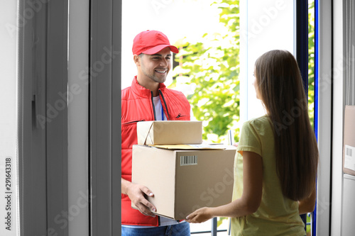 Foto Woman receiving parcels from courier on doorstep