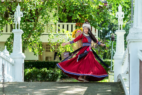 Young woman dancing and spinning in a curvy traditional dress.  Beautiful Hmong  girl spins the skirt.