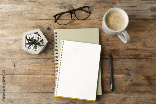 Flat lay composition with office stationery and cup of coffee on wooden table. Space for design