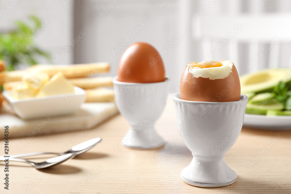 Cups with soft boiled eggs on wooden table, space for text. Healthy breakfast Cups with soft boiled eggs on wooden table, space for text. Healthy breakfast