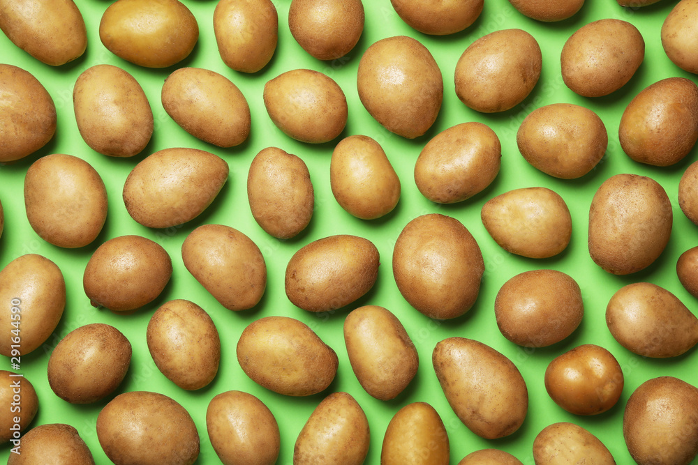 Raw fresh organic potatoes on green background, flat lay