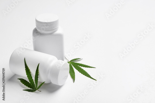 Hemp leaves and pill bottles on white background. Space for text