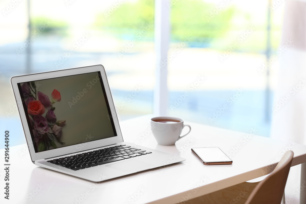 Comfortable workplace with modern laptop on desk in home office, space for text Comfortable workplace with modern laptop on desk in home office, space for text