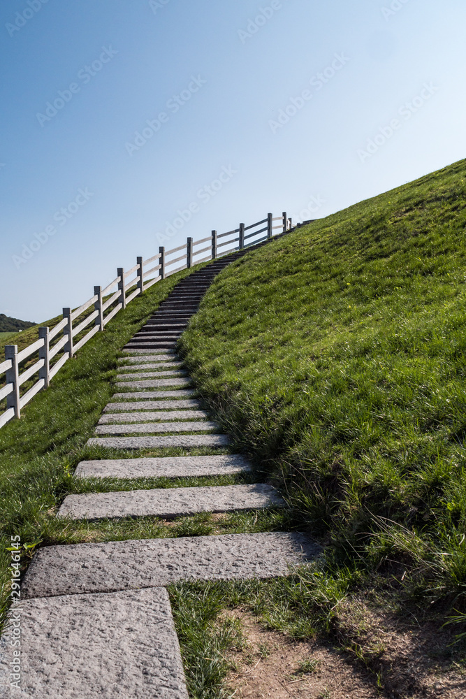 stone stairs uphill with white fences on the side under bright blue sky