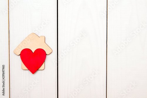  The symbol of the house with heart on wooden background 